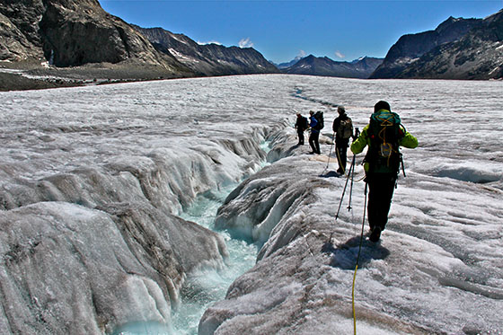 A large stream of water runs down the glacier.