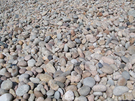 It's actually made of large and perfectly smooth granite pebbles 
 some as big as a melon 
 This accumulation of large pebbles gives an idea about what the sheer power of the winter storms must be like